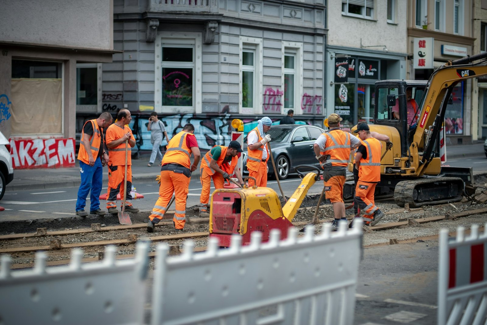 Bautrupp in Warnkleidung bei Tiefbauarbeiten in einer Stadtstraße